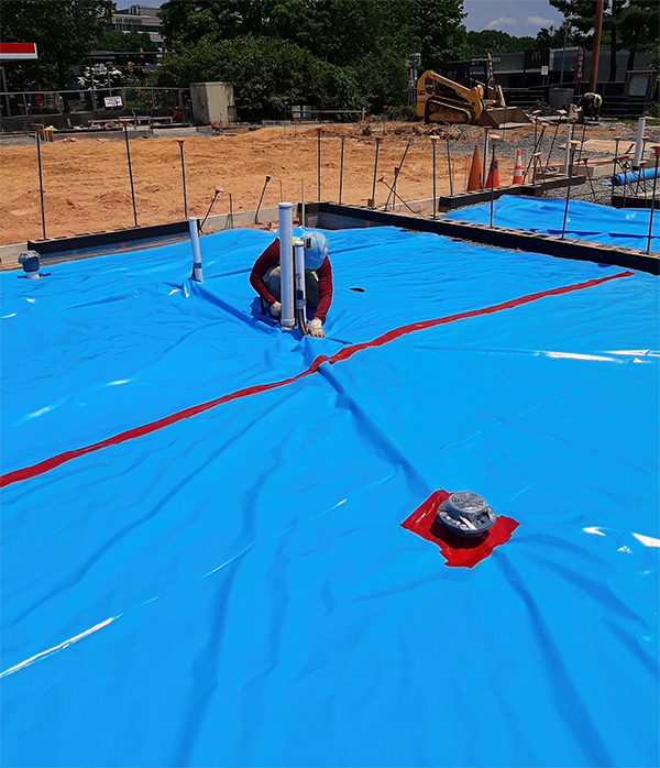 Impermeable membrane placed around floor drains and piping stubouts in prepartion for concrete pour